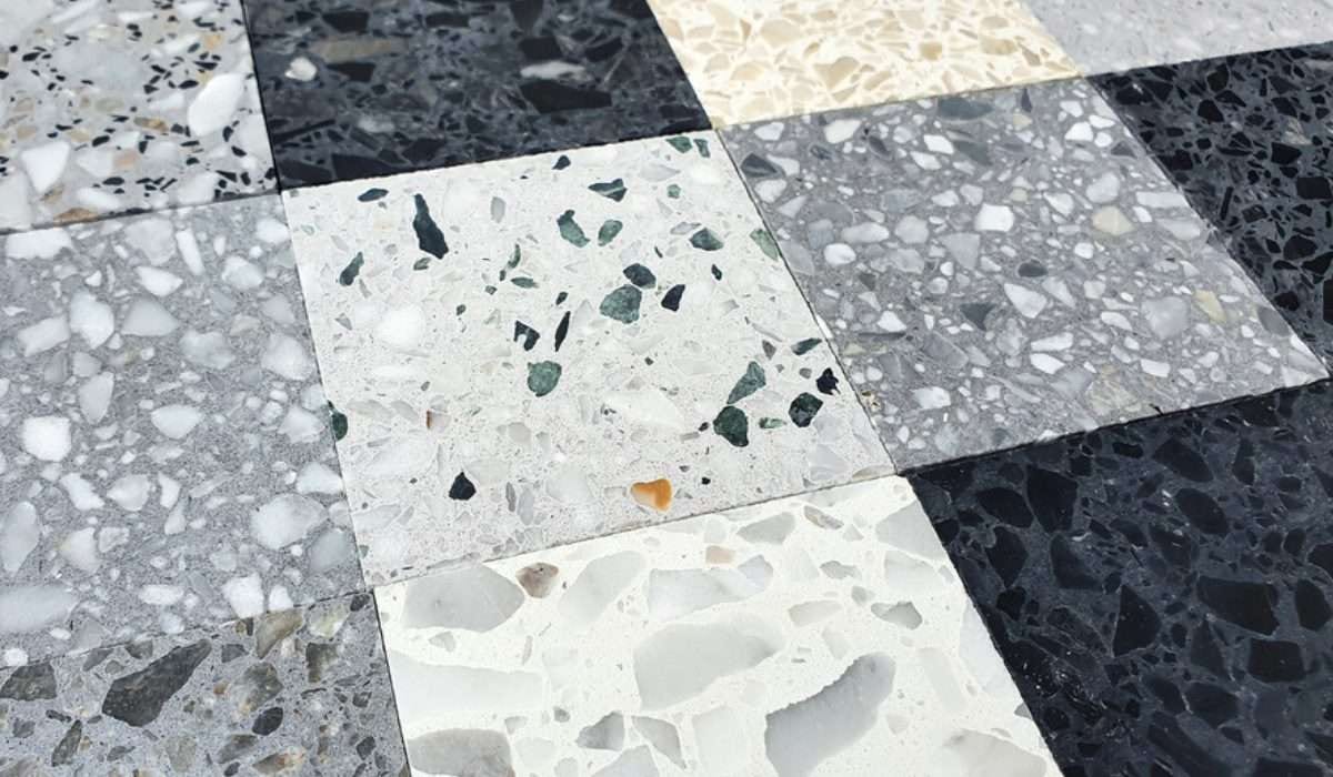 Terrazzo tiles in grey, white and black laid in a checkerboard.