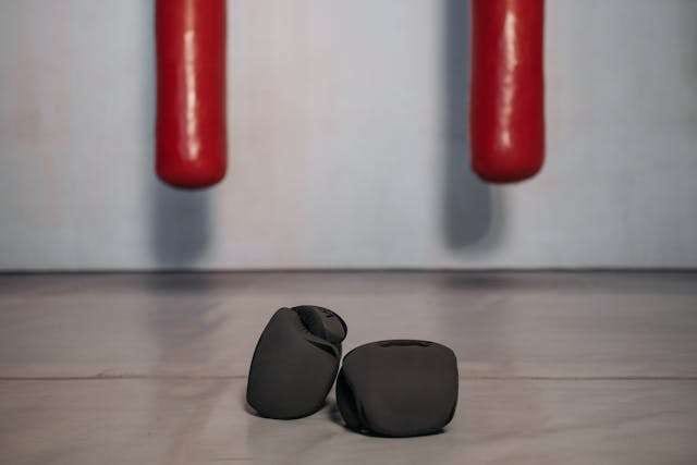 Two black rubber pads below the red legs of a piece of furniture on a grey floor.