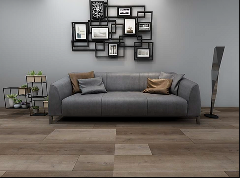 Multi-tone wood-look plank flooring in a living room with a grey sofa and a gallery wall of black frames.