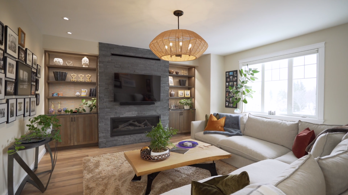 Light wood-look plank flooring in a living room with a stone fireplace, built-in shelving and a cream sectional.