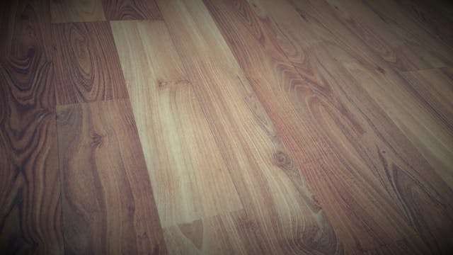 Close-up of wood-look laminate planks in mixed brown tones.