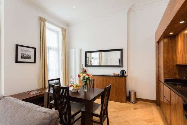 A dining nook with a dark table and chairs on a light wood floor.