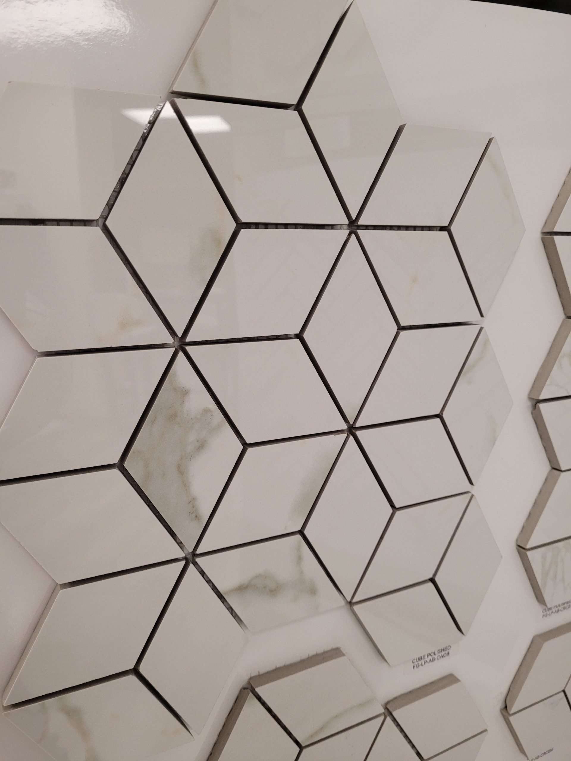 White marble-look tiles arranged in a three-dimensional cube pattern on a display wall