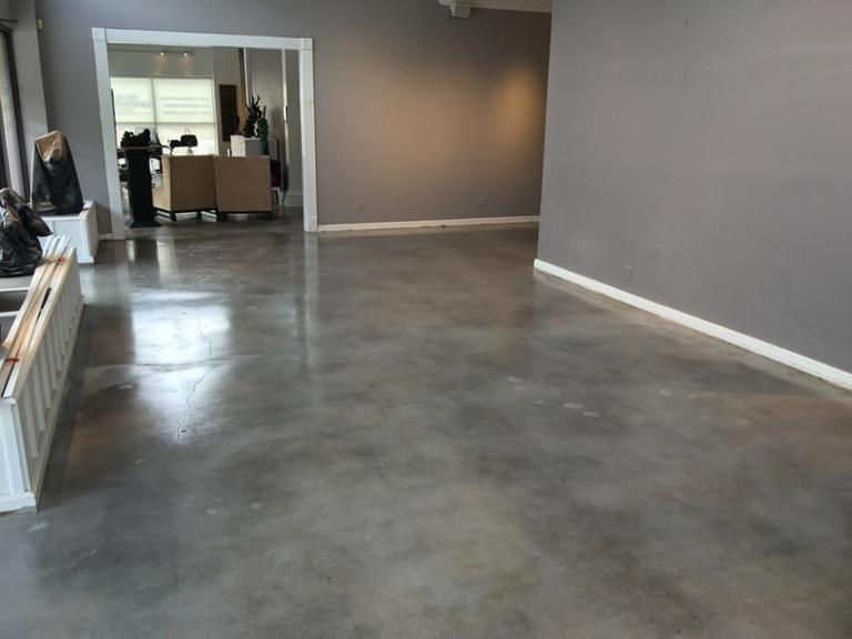 An empty room with a polished grey concrete floor.