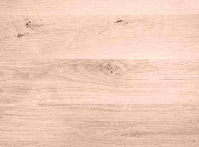Close-up of pale oak-look planks with knots in the grain.