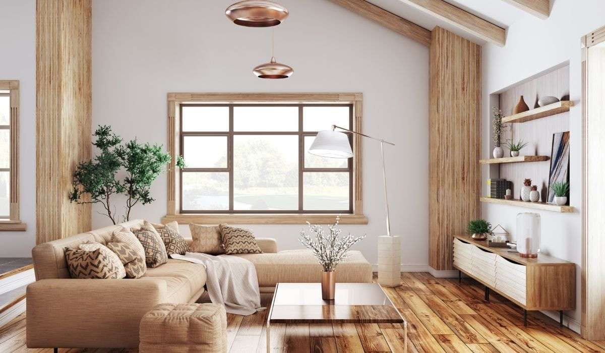 Warm wood plank flooring in a living room with a beige sectional, low coffee table and wood-clad accent walls