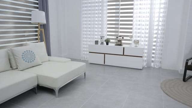 A white living room with pale grey large-format floor tile and a white chaise sofa.