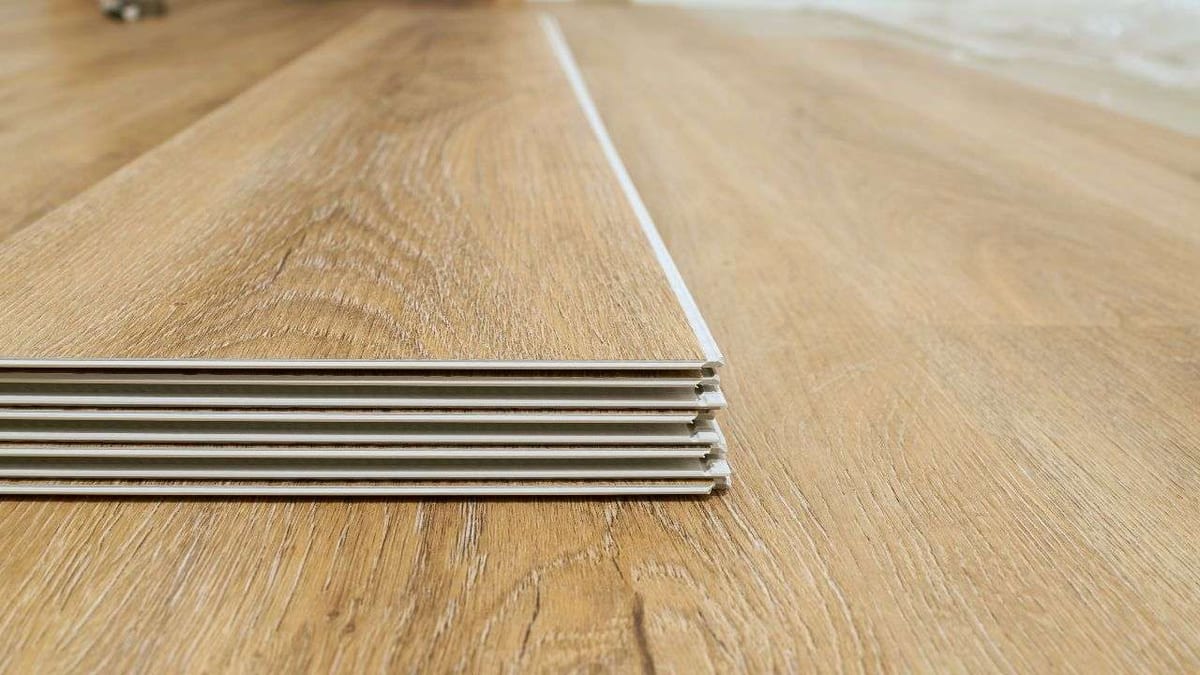 A stack of wood-look vinyl planks showing their thin layered edges.