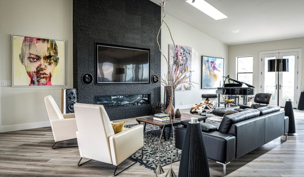 Modern, chic living room with black sofa, white chairs, and luxury vinyl that's one of the best living room flooring options