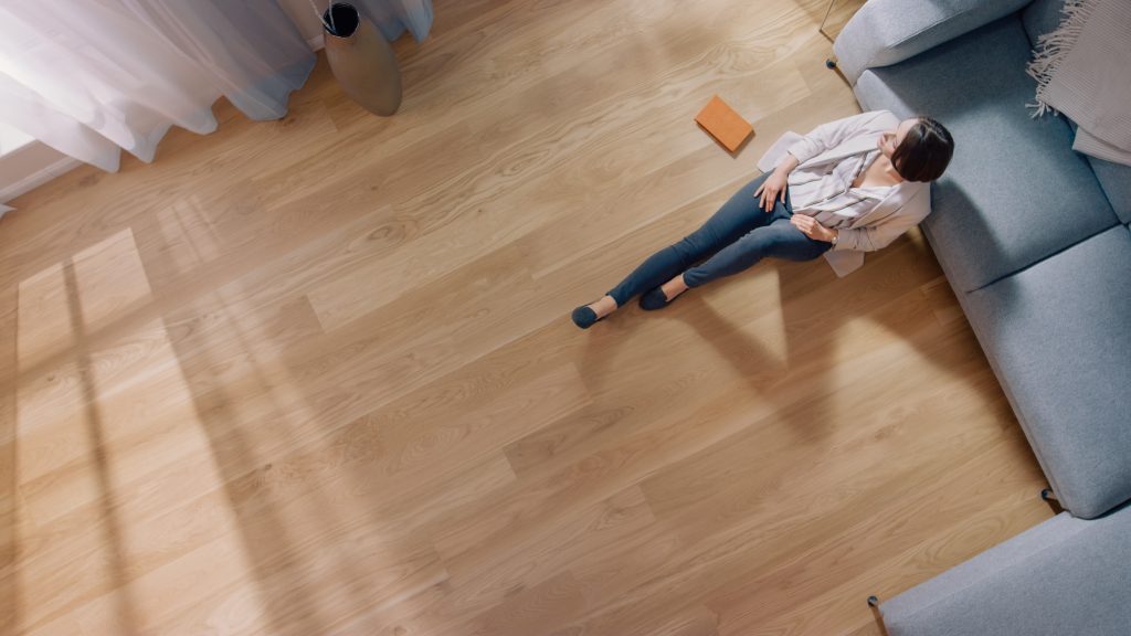 top down view of woman sitting on hardwood flooring